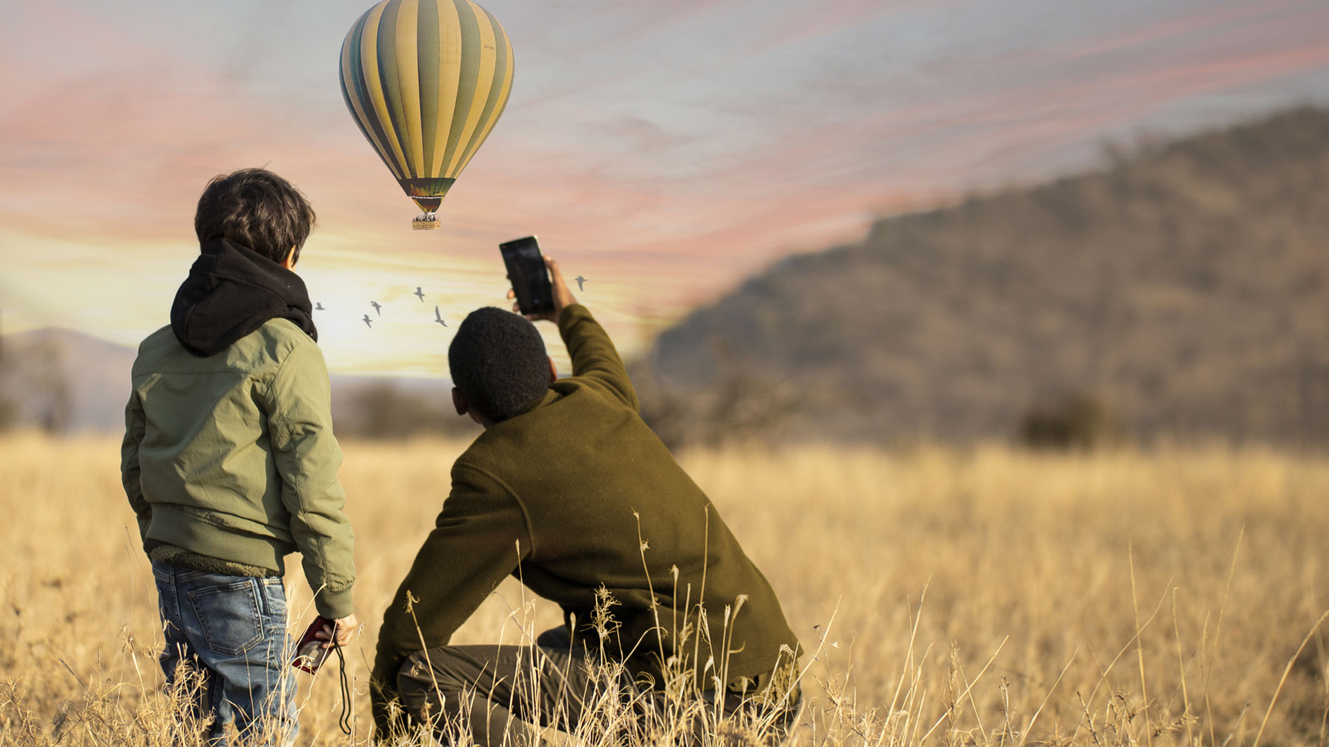 Safari for Family. Father and Son enjoying the view of Hot air Balloon in Serengeti
