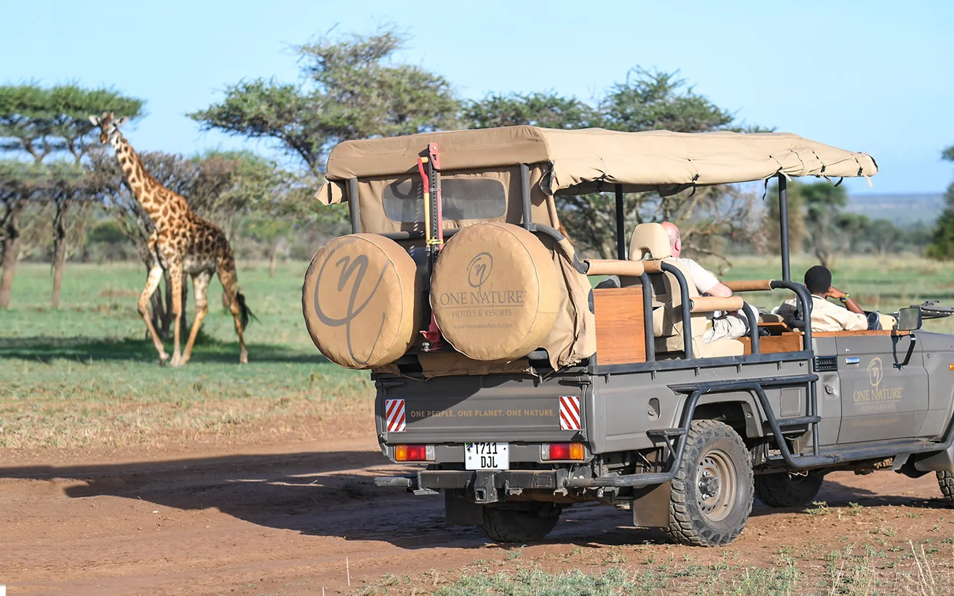 Guests enjoying a game drive watching the giraffe in the Serengeti.