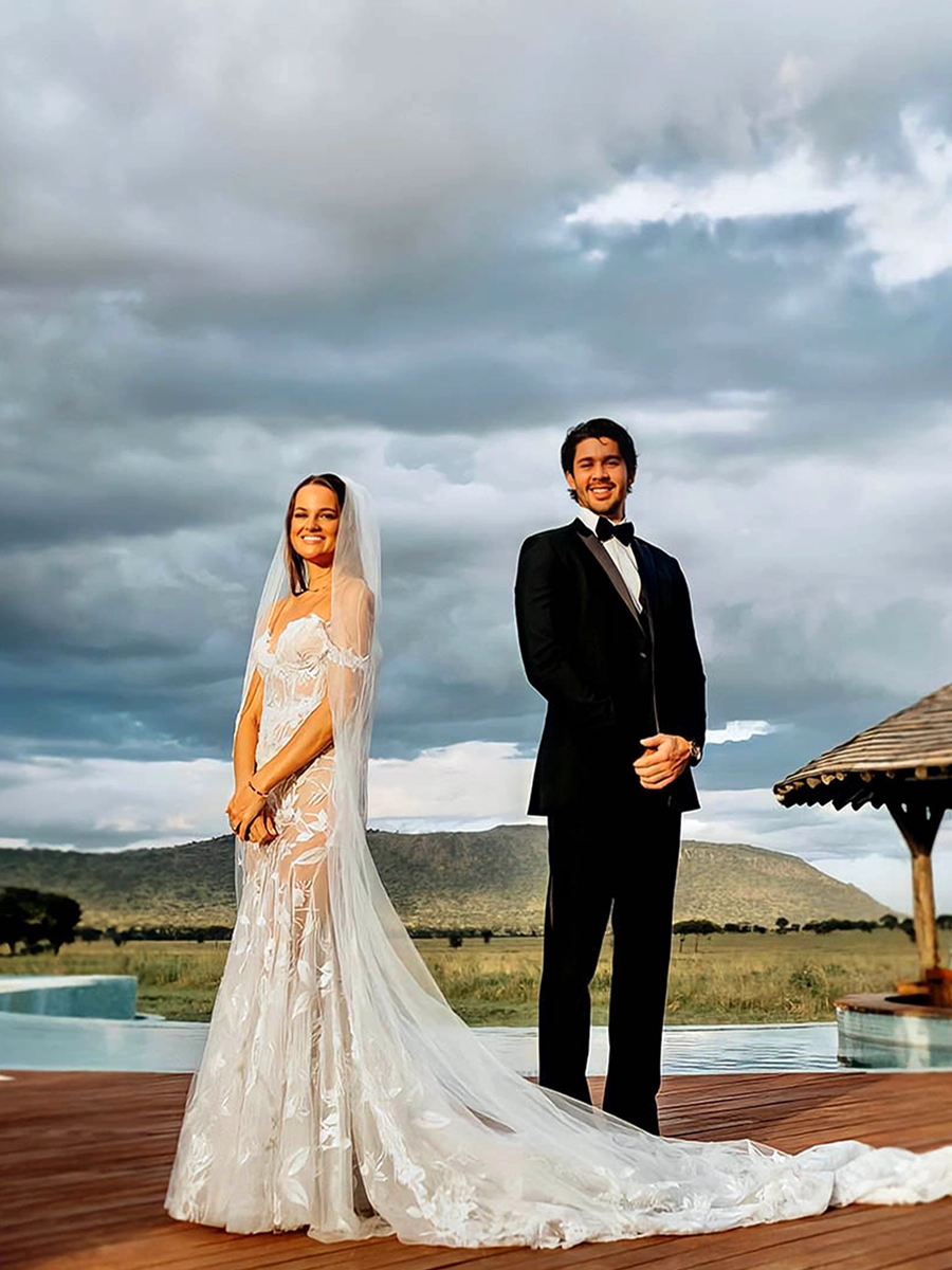 Wedding couple near the One Nature Nyaruswiga pool with stunning Serengeti views.