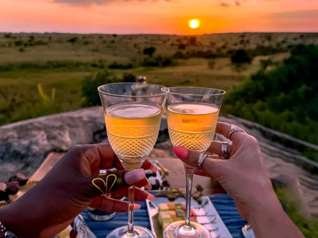 Christmas sundowner celebration in Serengeti with champagne, goldensunset, and luxury safari holiday charm.