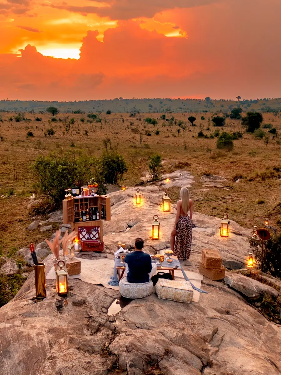 A couple enjoying a romantic African sundowner at sunset, celebrating Valentine’s Day in Serengeti’s savannahs.