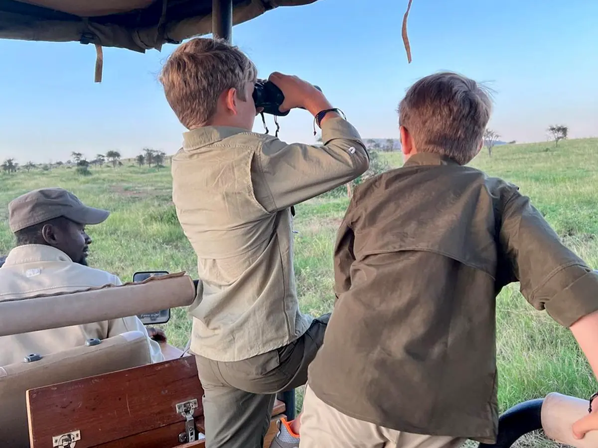 Kids enjoying a luxury African safari in the Serengeti on a guided game drive during their spring break.
